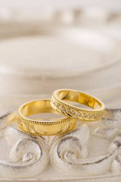 istock Two gold wedding rings on beige background 1018095536