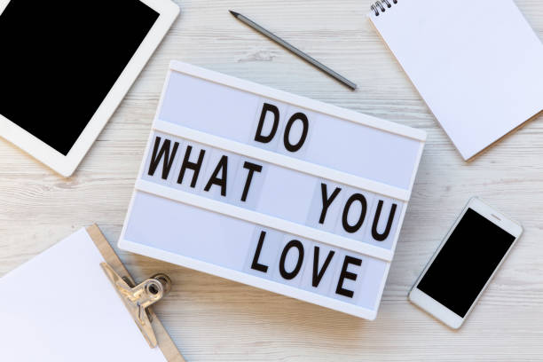 istock Workspace with clipboard, pencil, notepad, phone, tablet and modern board with text 'Do what you love' on white waooden background. From above, flat lay, overhead. 1018095654