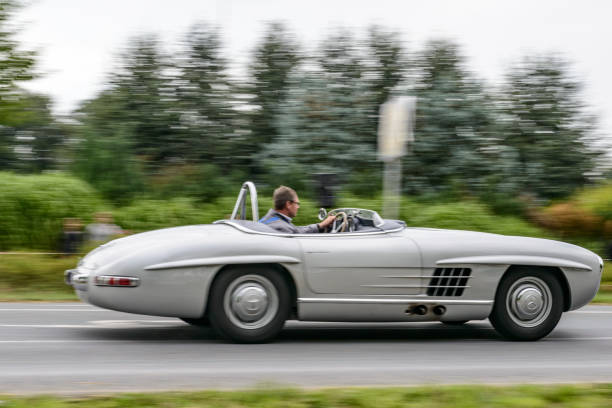 Mercedes-Benz 300 SLS Roadster classic lightweight racing car driving on a country road Mercedes-Benz 300 SLS Roadster classic lightweight racing car driving on a country road. The SLS is a lightweight and more powerful edition of the famous 300 SL Gullwing sports car. The car is doing a demonstration drive during the 2017 Classic Days event at Schloss Dyck. 1950s racing car stock pictures, royalty-free photos & images