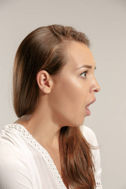 istock Beautiful woman looking suprised isolated on gray 1018098658