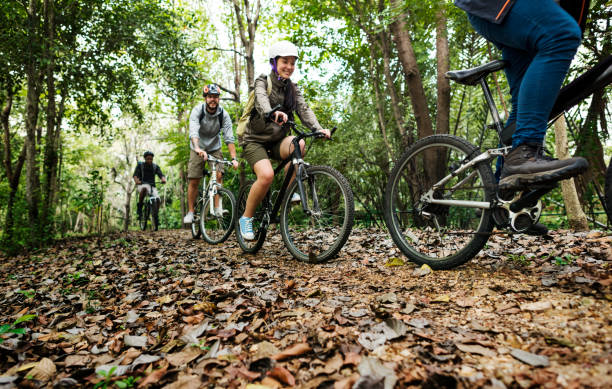 Group of friends ride mountain bike in the forest together Group of friends ride mountain bike in the forest together mountain bike photos stock pictures, royalty-free photos & images