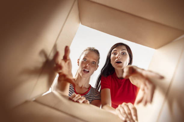 istock Women unpacking and opening carton box and looking inside 1018106394