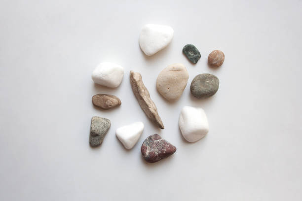 A close-up, high-angle view of a dense collection of small, multi-coloured pebbles and stones, on the banks of the River Thames in London. he mix includes natural stones, as well as fragments worn down bricks.