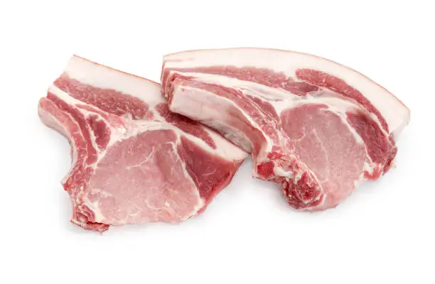 Two uncooked pork loin chops with ribs on a white background