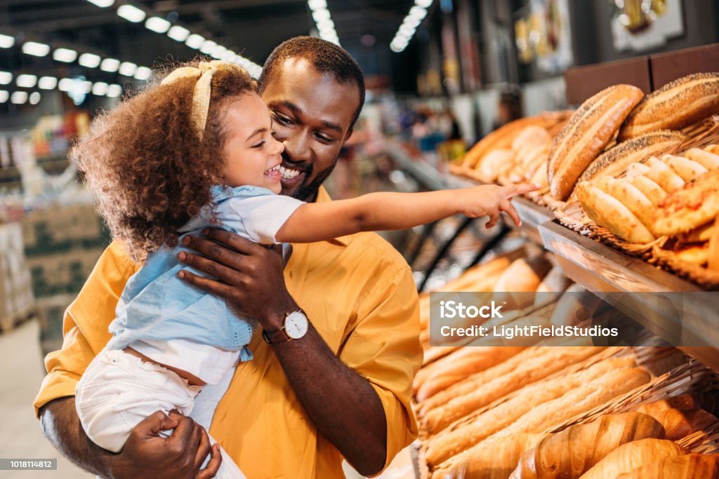 afro-américaine petit enfant pointant au doigt à la pâtisserie au père dans le supermarché - Photo de Supermarché libre de droits
