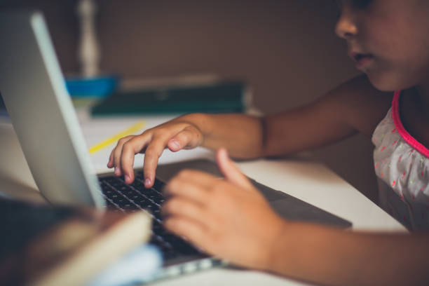 istock Little girl typing on computer. 1018117490