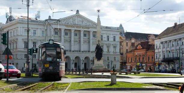 ARAD, ROMANIA - SEPTEMBER 13, 2017: Traditional electric tram running on background with Arad State Theater