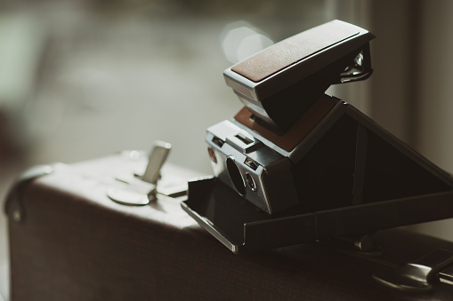 Vintage snapshot camera on an old suitcase with an open lock