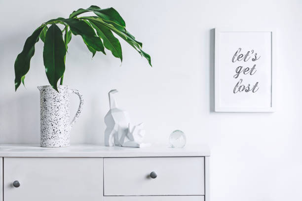 istock Stylish and modern white interior with mock up frame , cacti and cat figures. White concept of cupboard shelf. 1018121398