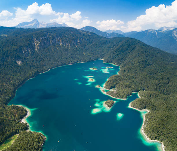 Aerial of the beautiful Lake Eibsee at the foot of the famous and highest Mountain Zugspitze in Bavaria, Southern Germany. Lots of tourists enjoying this perfect summer day on the lake. Converted from RAW.