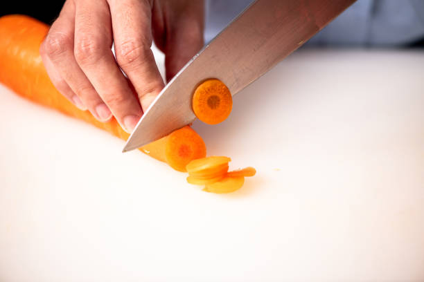 istock Woman chopping carrots in kitchen. 1018134416