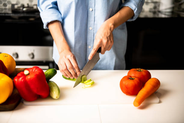 istock Woman chopping cucumber in kitchen. 1018134430