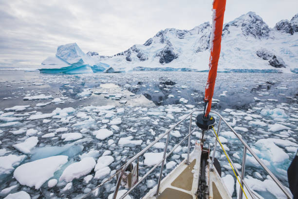 istock sailing boat in Antarctica, yacht navigation through the ice 1018139248