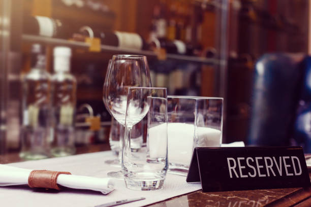 Reserved sign on a table in restaurant. Empty glasses set in restaurant
