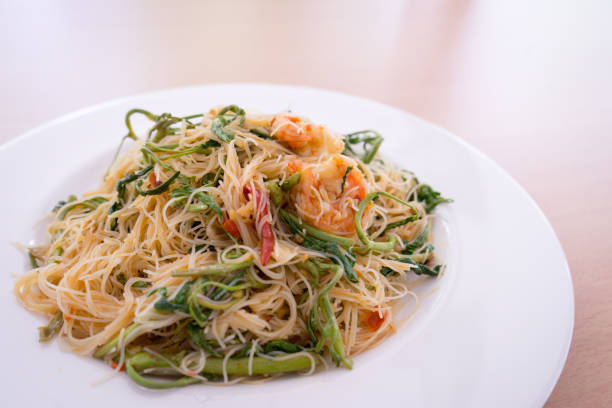 Thin rice noodles stir fried with shrimp and water minosa or Mee Phat Krachet Koong in Thai
