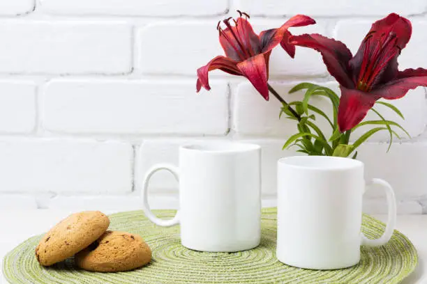 Photo of Two coffee mug mockup with red lily and cookie