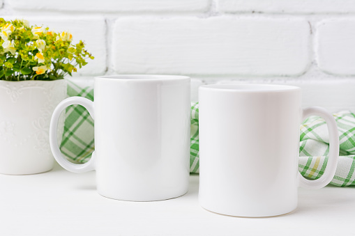 Two white coffee  mug mockup with small yellow and green flowers.  Empty mug mock up for design promotion.