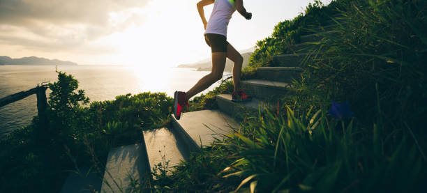 istock Determined woman running up on seaside mountain stairs 1018143472
