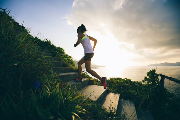 istock Determined woman running up on seaside mountain stairs 1018146070
