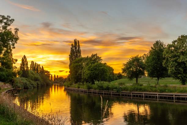 Sunset over the river. A dramatic sunset over a bend in the River Ouse in York.  A path runs alongside a tree-lined river bank. ouse river photos stock pictures, royalty-free photos & images