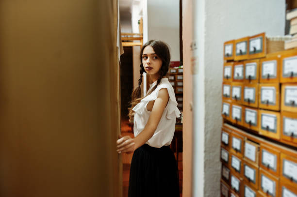 istock Girl with pigtails in white blouse at old library. 1018158434