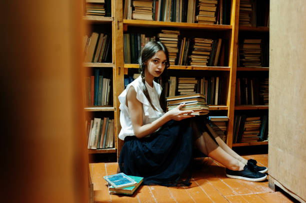 istock Girl with pigtails in white blouse at old library. 1018158638