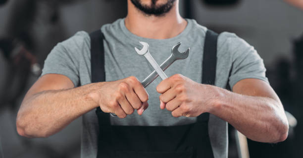 istock cropped view of auto mechanic holding two wrenches 1018158954