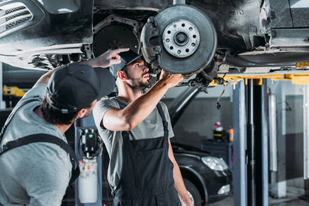istock auto mechanics repairing car without wheel in workshop 1018159094