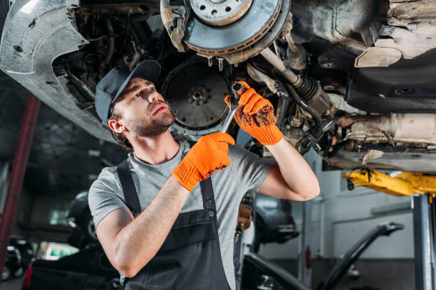 istock mechanic repairing car without wheel in workshop 1018159116