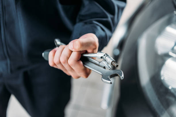 istock cropped view of workman holding tools and wrenches in hand 1018168734