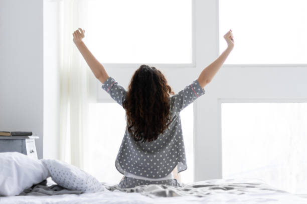 молодая девушка в пижамной пижаме пижамы. утро слабый вверх концепции - waking up women bedding underwear стоковые фото и изображения