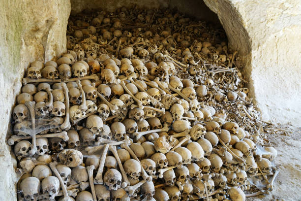 huge pile of human skulls and bones in an underground cave
