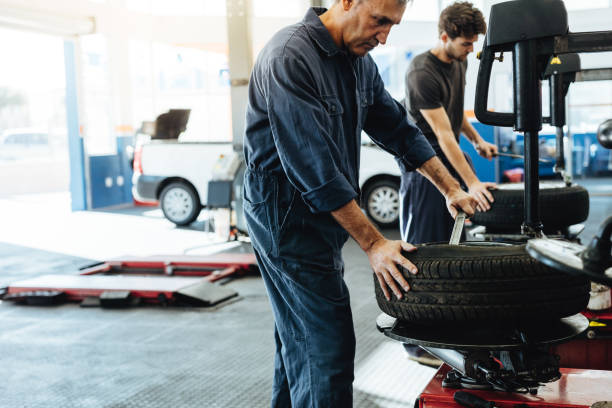 istock Mechanics working on tire replacing machines in service station 1018187614