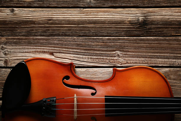 istock Violin on brown wooden table 1018187952
