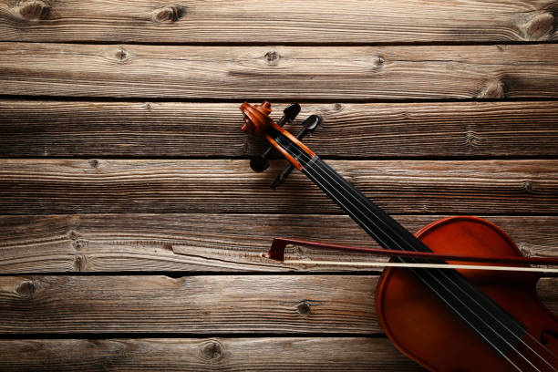 istock Violin with bow on brown wooden table 1018188252