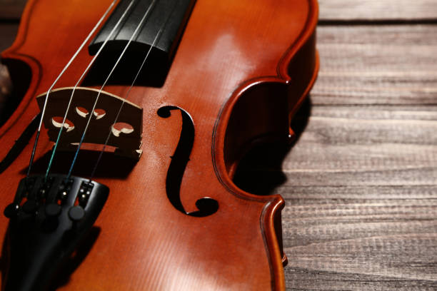 istock Violin on brown wooden table 1018188380
