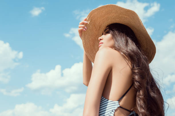 istock attractive brunette girl posing in straw hat with blue sky on background 1018198712