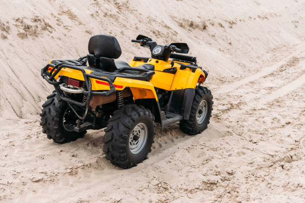 istock yellow all-terrain vehicle parked on sand 1018199406
