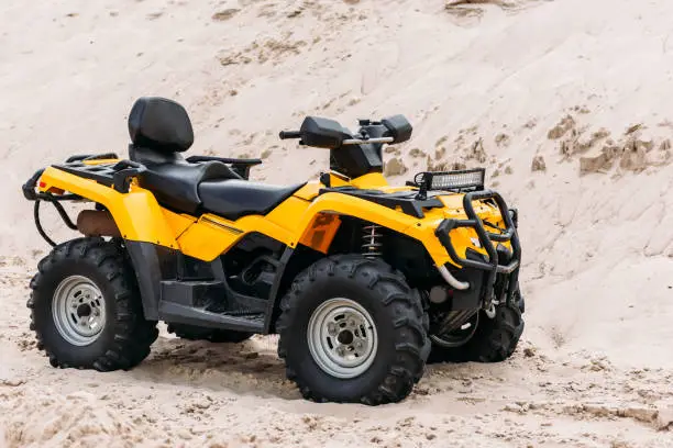 modern yellow all-terrain vehicle on sand