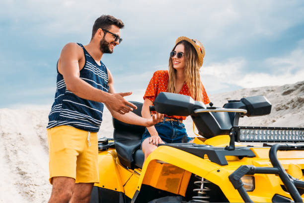 istock happy young man teaching his girlfriend how to ride atv in desert 1018199480