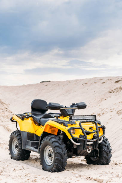 istock modern yellow all-terrain vehicle standing in desert on cloudy day 1018199508