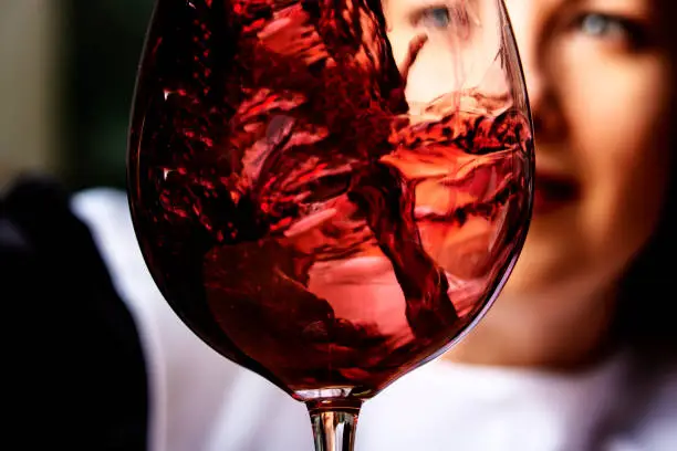 Woman pours red wine into a wineglass