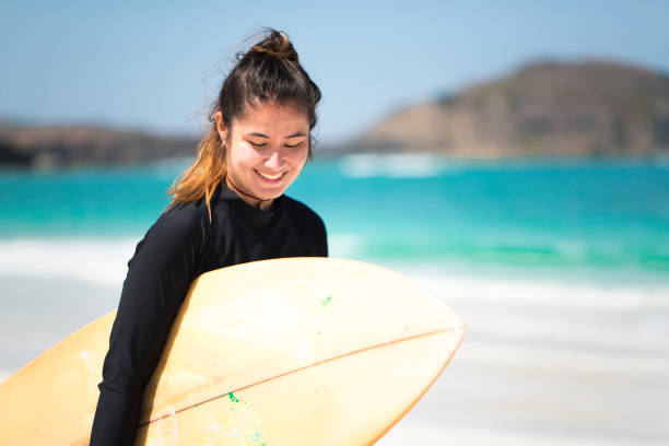 istock Young woman with a surfboard 1018204078