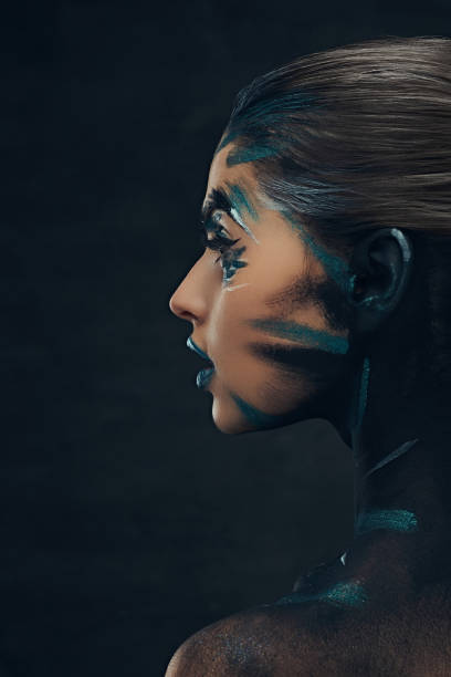 istock A young sensual girl with creative make-up. Blue and black shadows painted on her face. Conceptual idea. 1018207228