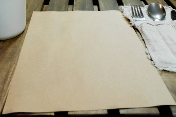istock Piece of paper is on wooden table near flatware set 1018214384