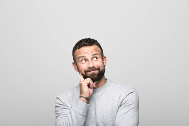 istock Portrait of surprised bearded young man looking up, grey background 1018215178