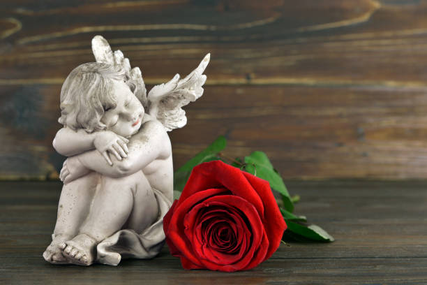 istock Little angel and red rose 1018217972
