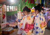 浴衣祭りで屋台の日本市場での買い物で若い女性の友人