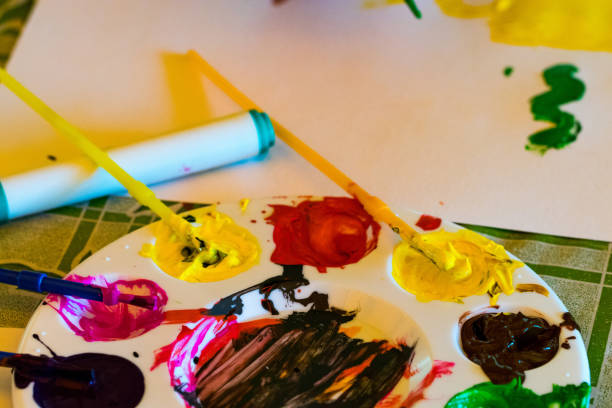 istock art palette with paints and paintbrush on canvas close-up 1018237720