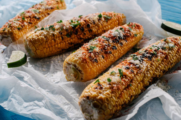 istock selective focus of grilled salted corn with lime slices on baking paper on wooden table 1018238088